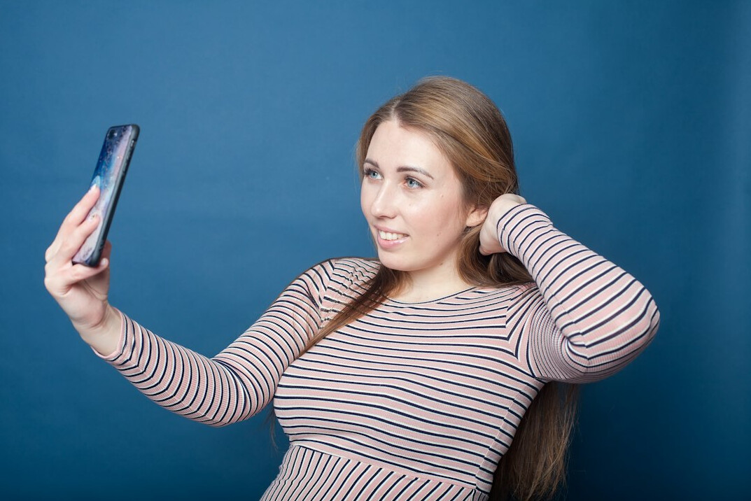 Smiling woman on a video call with a laptop in a bright office